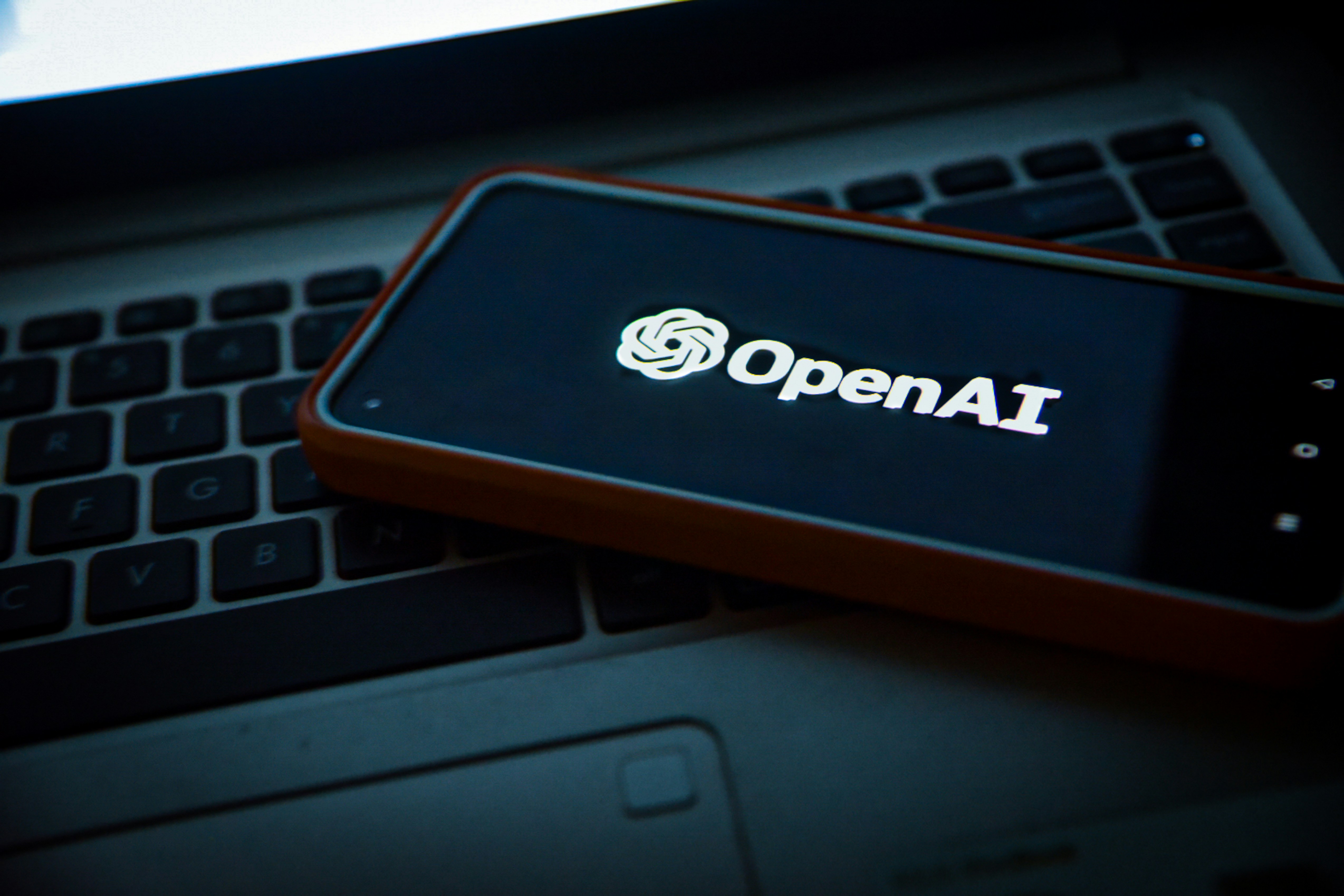 Phone on Computer with OpenAI logo